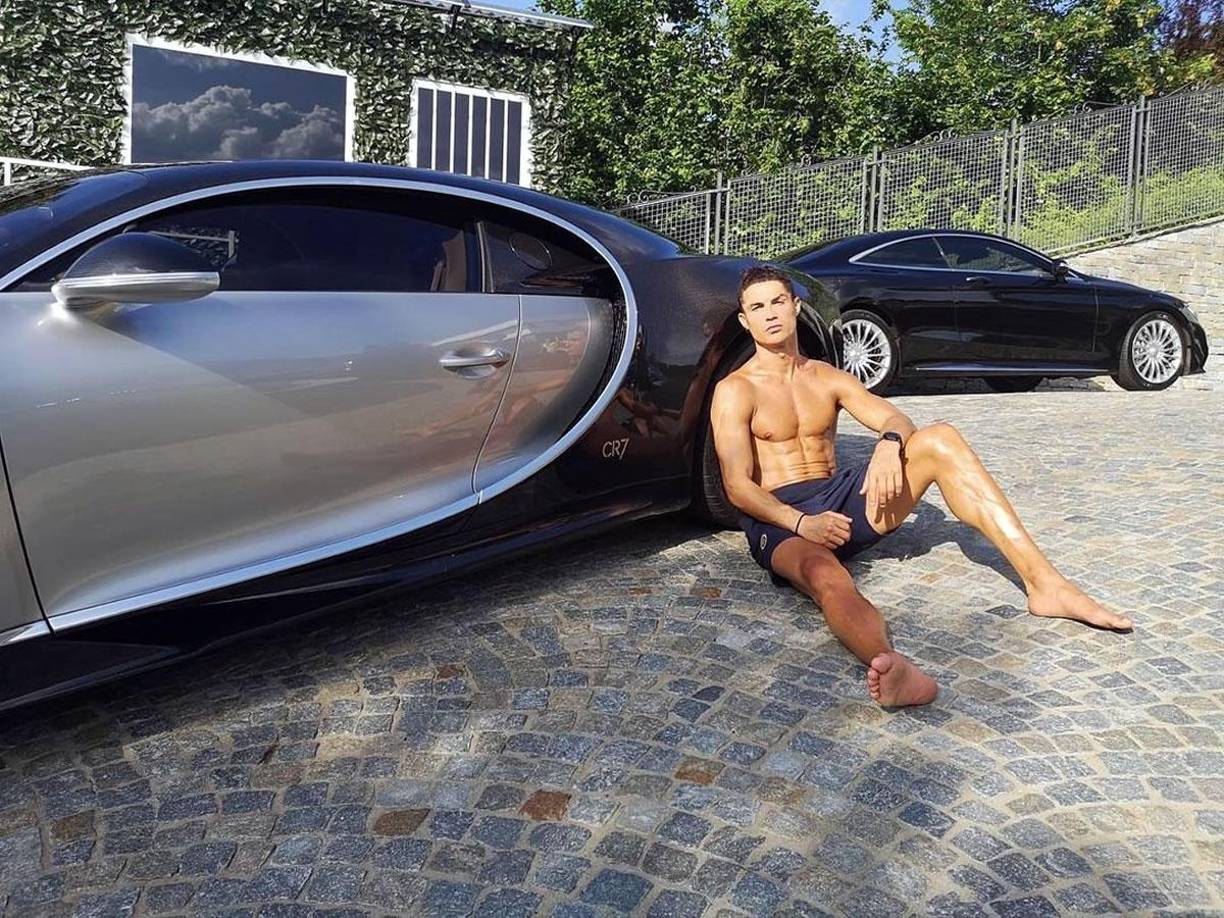 Bugatti Chiron - Cristiano Ronaldo tomando el sol a la par de máquina que es capaz de alcanzar los 100 km/h en 2,5 segundos. Todo ello gracias a una potencia que alcanza los 1.500 caballos y un par motor de 1.600 Nm entregado entre 2.000 y 6.000 revoluciones por minuto. Cuesta más de tres millones de euros.
