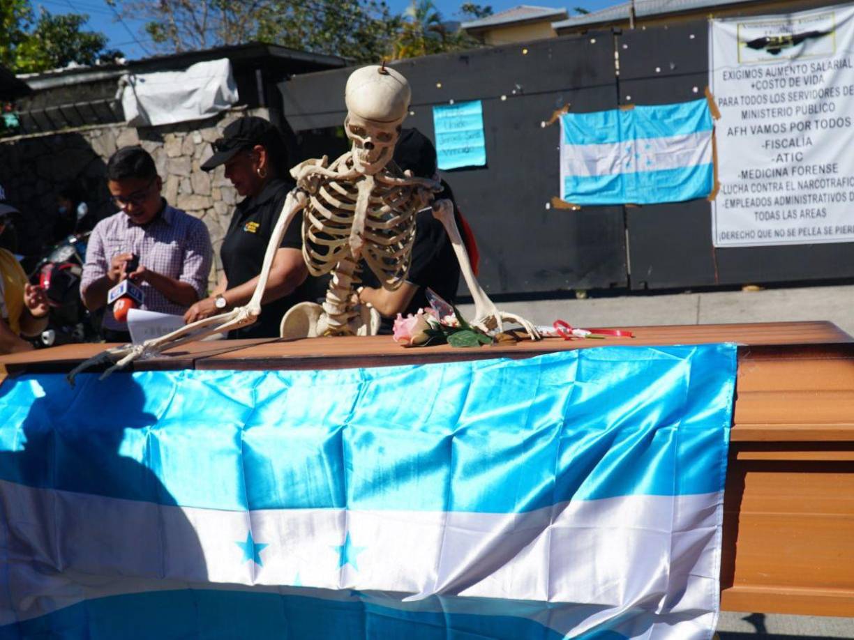 Este ataúd con una calavera y una cinta amarilla fue colocada en la morgue del Ministerio Público en donde continúa la huelga en la que los empleados exigen un aumento. 