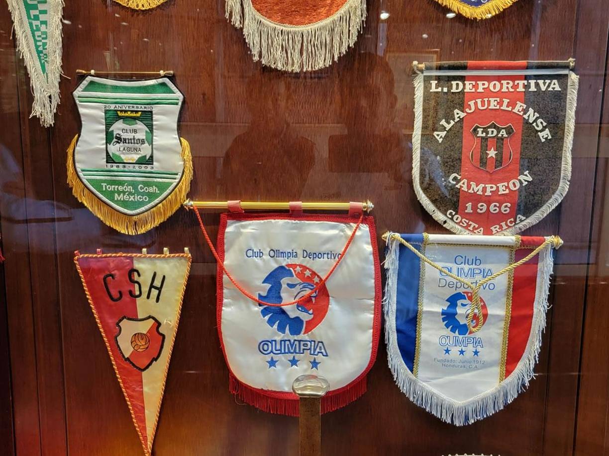 Asimismo, lucen en sus vitrinas el banderín o estandarte del Olimpia de las veces que lo han enfrentado