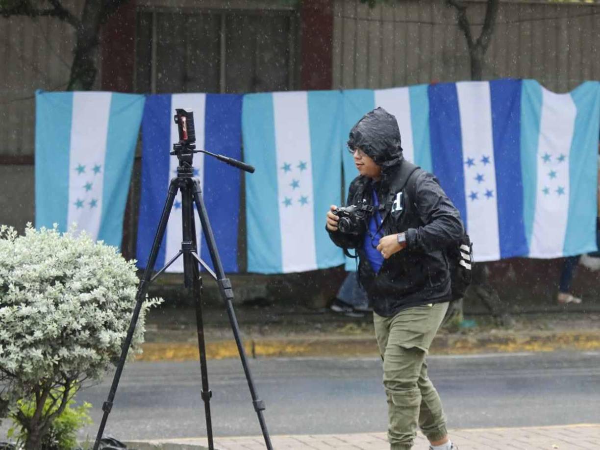 Mauricio Ayala, fotógrafo de Diario LA PRENSA, se colocó la chumpa de La H para evitar mojarse. ¡Cobertura total desde el Estadio Morazán!