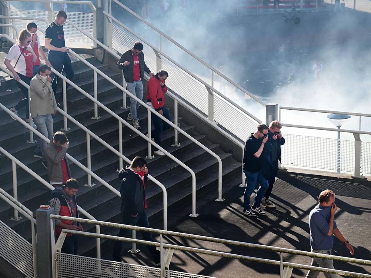 La afición en el momento que salía del estadio mientras se cubría tras el lanzamiento de bengalas. 