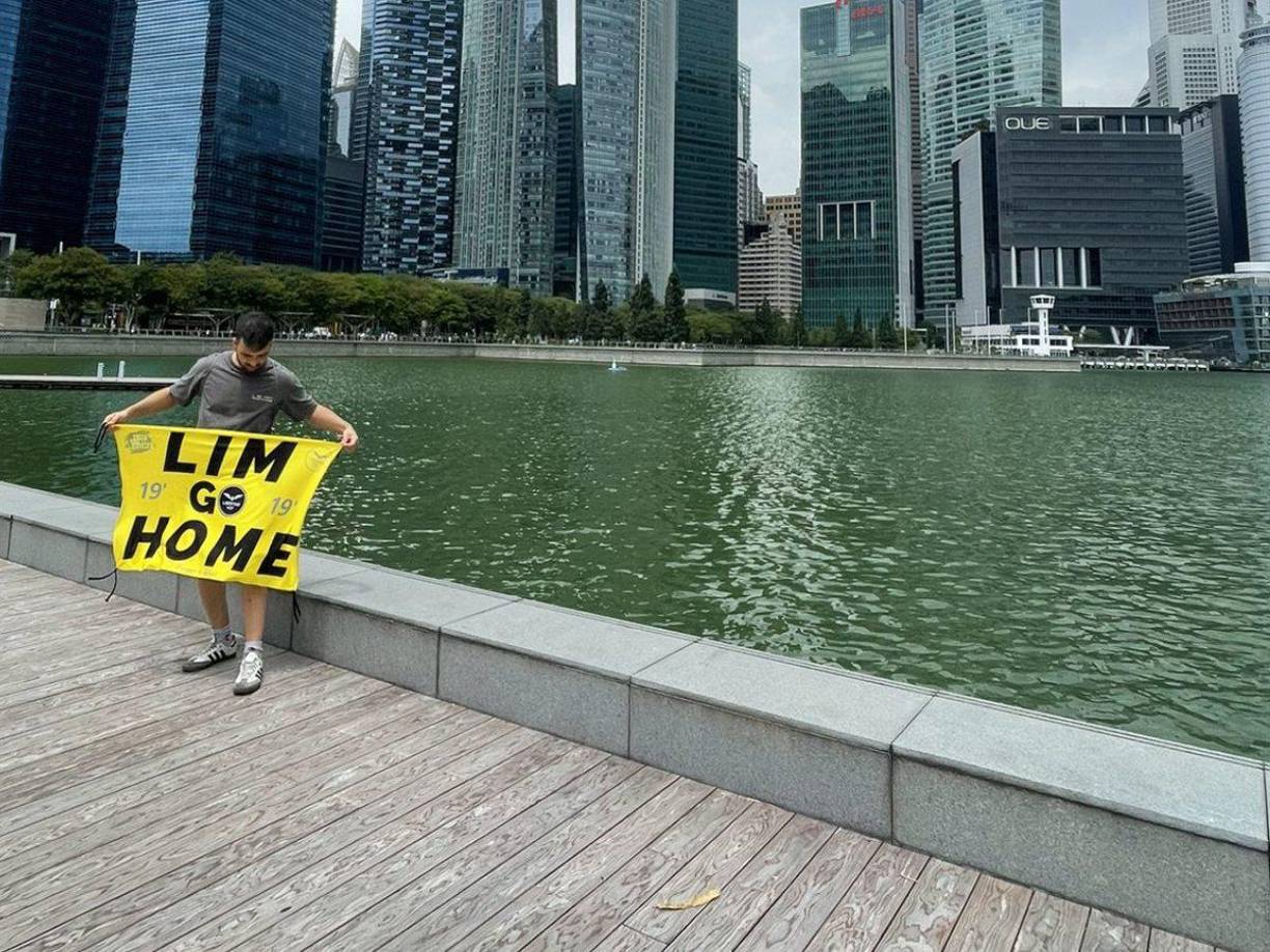Dani y su esposa llegaron a Singapur y mostraron la pancarta en la que exigen la salida de Peter Lim del Valencia. 
