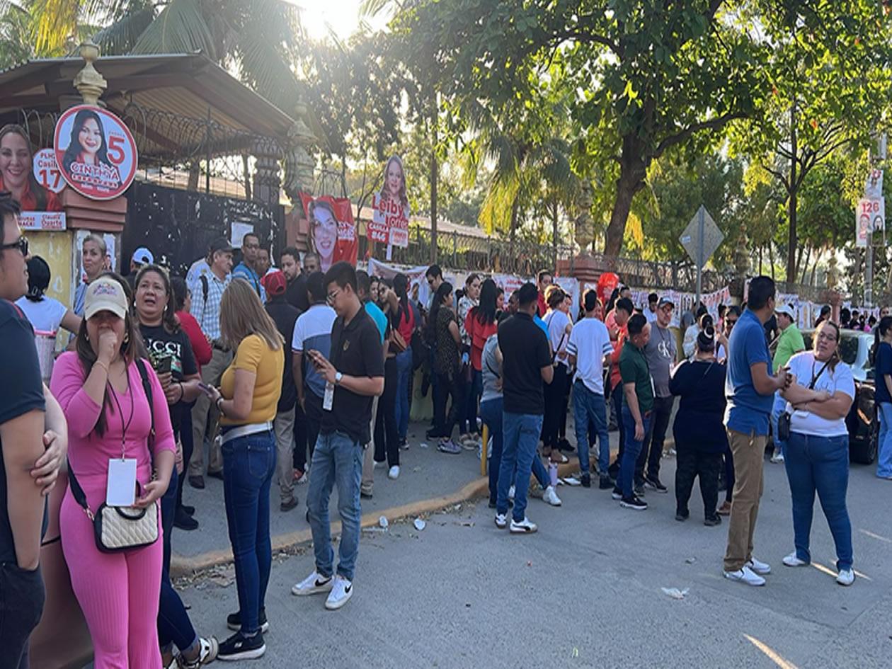Votantes esperan que abran los portones en la escuela Primero de Febrero
