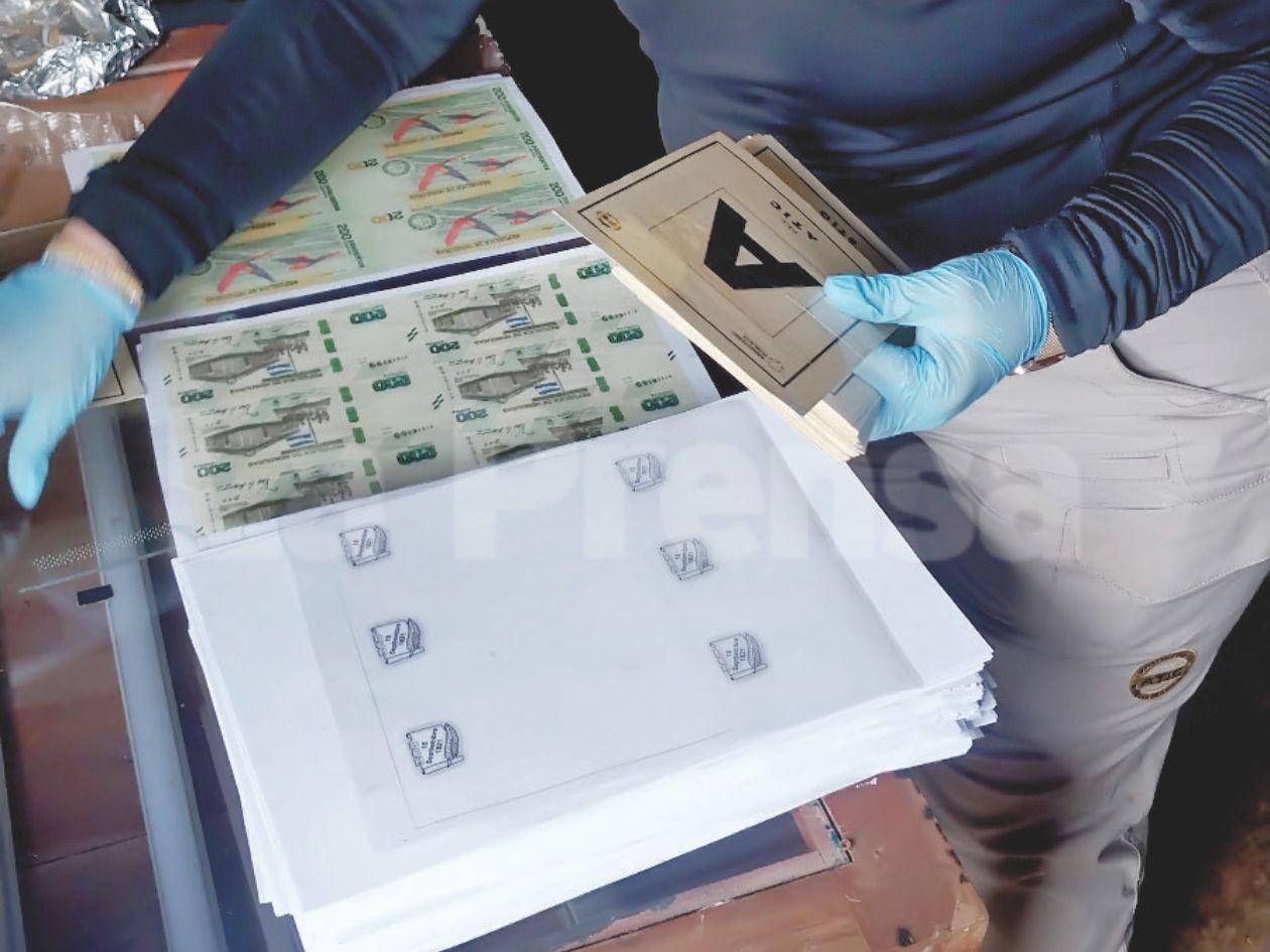 Envíos desde otras ciudades, así como entregas directas, son parte de los ofrecimientos que hacen los falsificadores en las redes sociales. Una agente muestra el material que se usaba para clonar billetes y que se incautó.