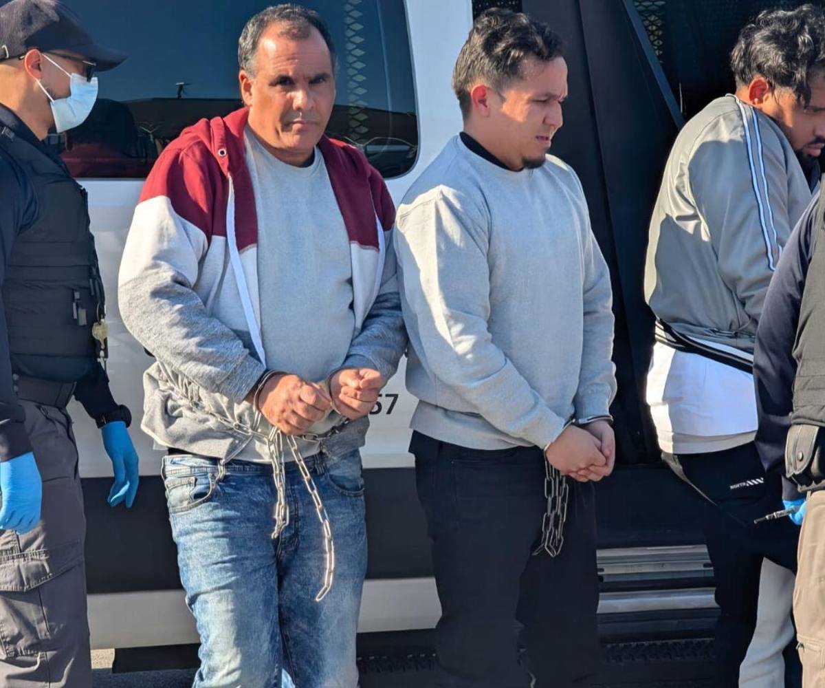 Diez personas descendieron de un bus encadenadas de pies y manos. Tras recibir sus pertenencias, fueron conducidas caminando hacia el control migratorio en México.