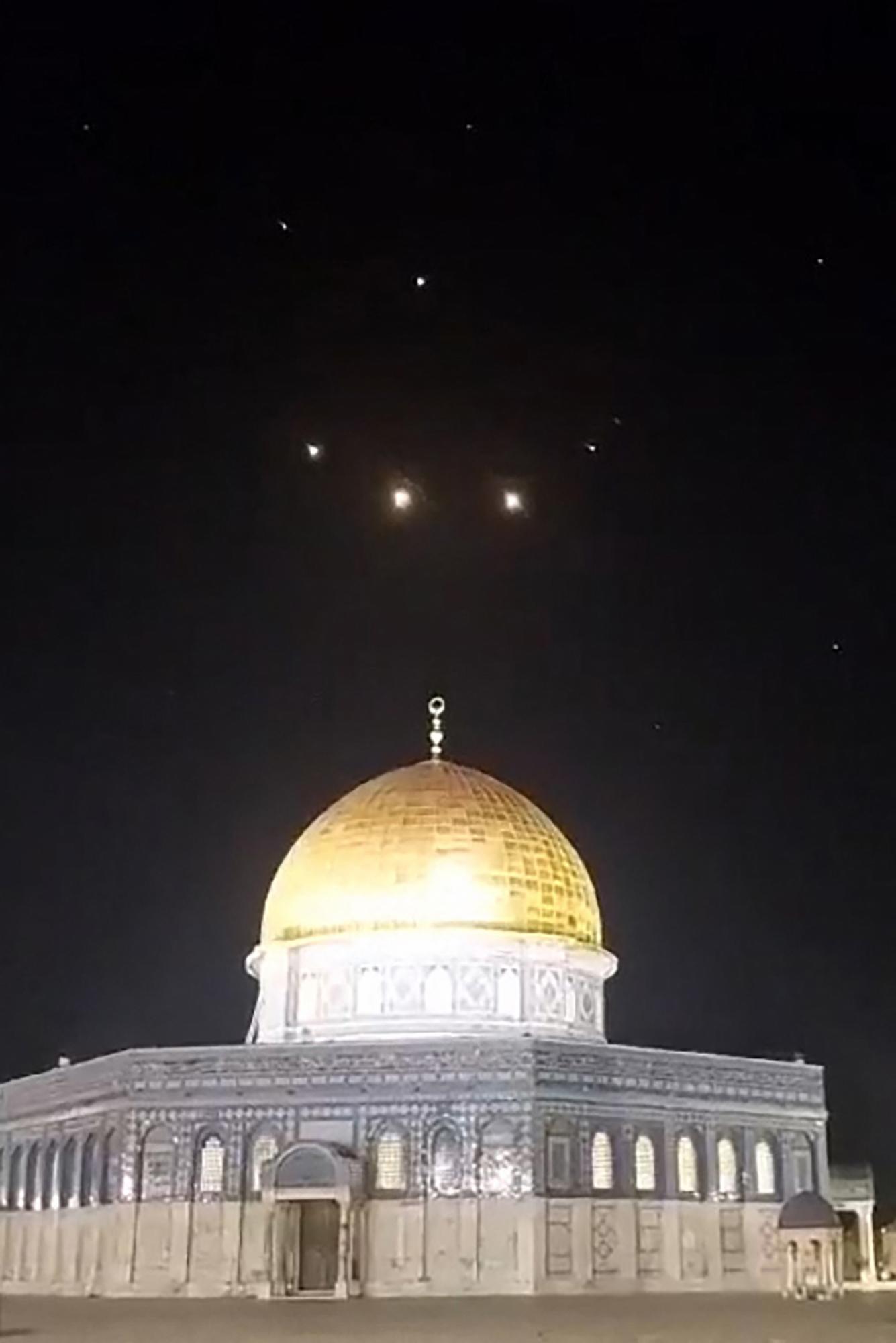$!Una captura de imagen de un vídeo tomada a primera hora del 14 de abril de 2024 muestra estelas de cohetes en el cielo sobre el recinto de la Mezquita de Al-Aqsa en Jerusalén.