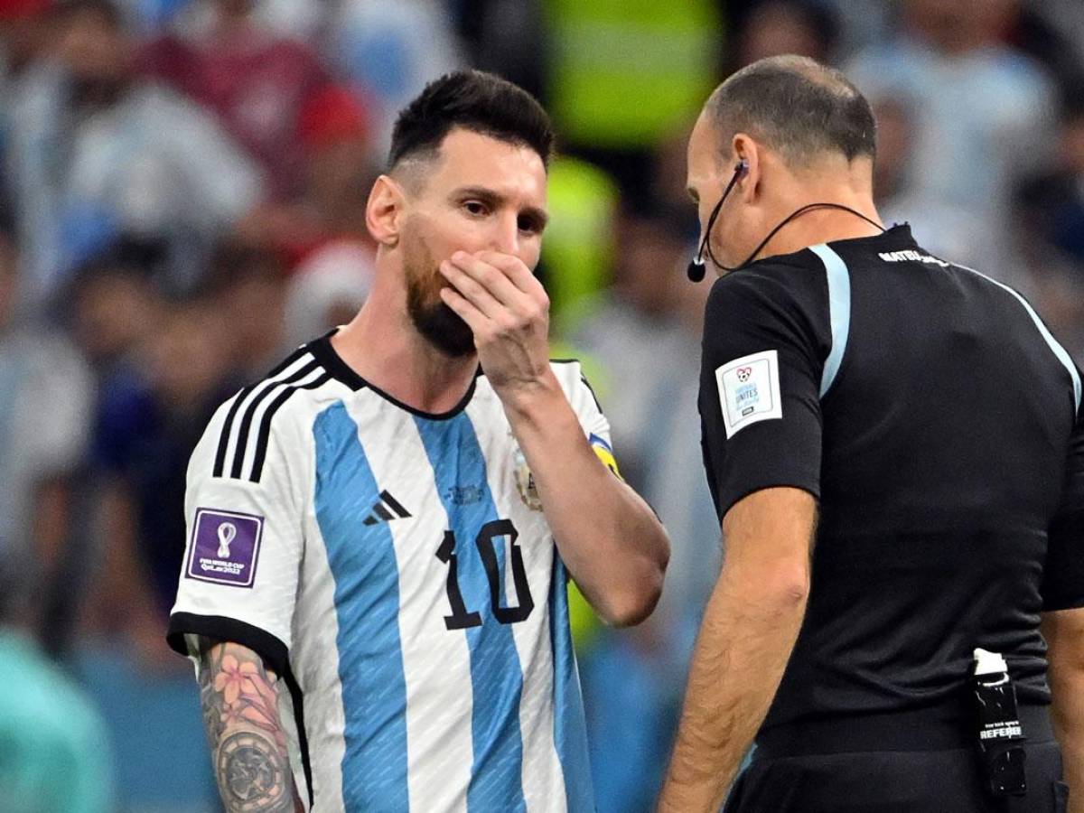 Lionel Messi se tapa la boca al dialogar con el árbitro Antonio Mateu Lahoz.