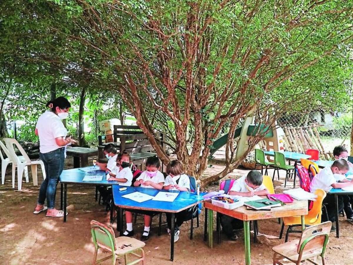 Niños reciben clases al aire libre.