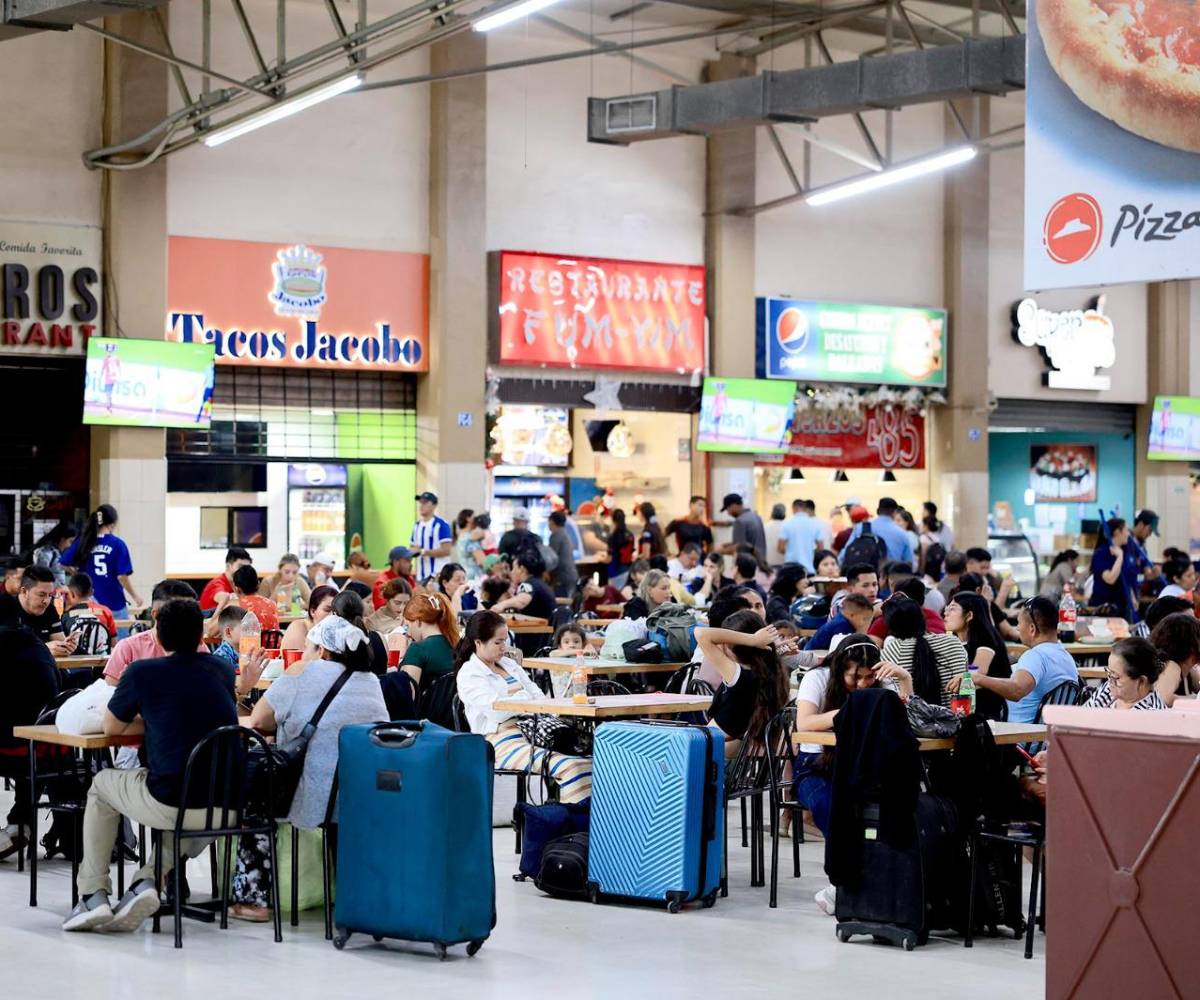 Pasajeros descansan junto a sus equipajes en el área de comidas de la Gran Central Metropolitana de San Pedro Sula. El incremento general del 17.25 % en las tarifas de los pasajes interurbanos obliga a los viajeros a limitar gastos tradicionales de la temporada, como la alimentación en el camino.
