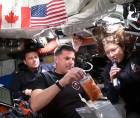 Captura de vídeo de la NASA donde aparecen los astronautas Reid Wiseman (i), Jeremy Hansen (c), y Christina Koch, mostrando los alimentos que consumen a bordo de la nave Orion de la misión lunar Artemis II.
