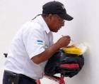 Hace unos días se viralizaron imágenes de un guardia de seguridad comiendo sobre una mochila colocada en la montura de su bicicleta.