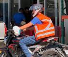 Motociclista hondureño con chaleco reflectivo en color naranja.