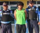 Agentes policiales y el hombre tras la detención.