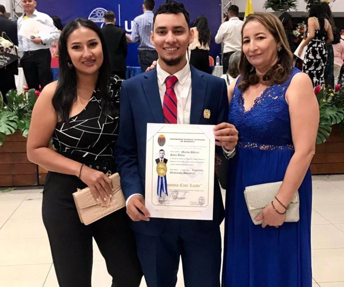 Marlon aparece sosteniendo su título el día de su ceremonia de graduación, acompañado de su madre y su hermana mayor.