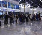 Pasajeros se forman en fila en el aeropuerto Ramón Villeda Morales una fotografía de archivo.