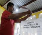 Una persona deposita su voto en una urna ayer domingo, en Tegucigalpa (Honduras). EFE/