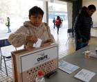 Una mujer deposita su voto en una urna este domingo, durante la segunda vuelta de las elecciones presidenciales en Perú, en Santiago.