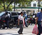 Pobladores circulan por la primera calle de San Pedro Sula en medio de intenso calor.