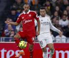 El delantero del Real Madrid, Kylian Mbappé, disputa un balón con el centrocampista del Sevilla, Djibril Sow.