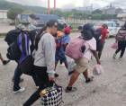 Migrantes hondureños avanzan con sus pertenencias por las calles de San Pedro Sula como parte de la nueva caravana que se dirige hacia Estados Unidos.