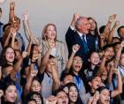 Asfura, su esposa, Lissette del Cid, y estudiantes hondureños. Fotografía cedida por Presidencia de Honduras (Facebook).