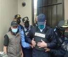 JOH salió de su residencia e inmediatamente policías le colocaron un chaleco antibalas y lo esposaron de pies y manos para trasladarlo a una unidad policial.