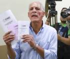 El candidato a la Presidencia de Honduras por el Partido Nacional, Nasry Asfura, muestra papeletas electorales antes de su de votación el domingo, en Tegucigalpa.