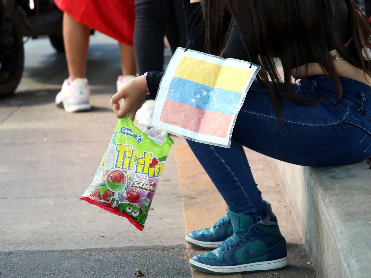 Decenas de migrantes venezolanos en Honduras sobreviven vendiendo paletas, una estrategia que les permite obtener ingresos mínimos para cubrir sus necesidades básicas.