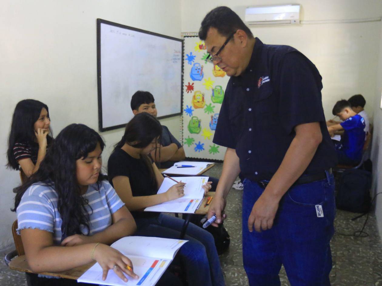Dentro del aula de clases el docente escribe y enseña con determinación, inspirando a alumnos y colegas a ver en la lucha contra el párkinson una oportunidad para crecer.
