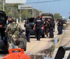 Integrantes del Ejército de México y policías estatales revisan vehículos este domingo, en el balneario de Cancún en Quintana Roo (México).