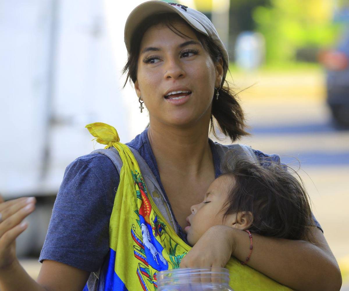 Ruth sostiene a su bebé mientras relata la dura travesía desde Venezuela hasta Honduras y cómo aún espera condiciones seguras antes de regresar a su país.
