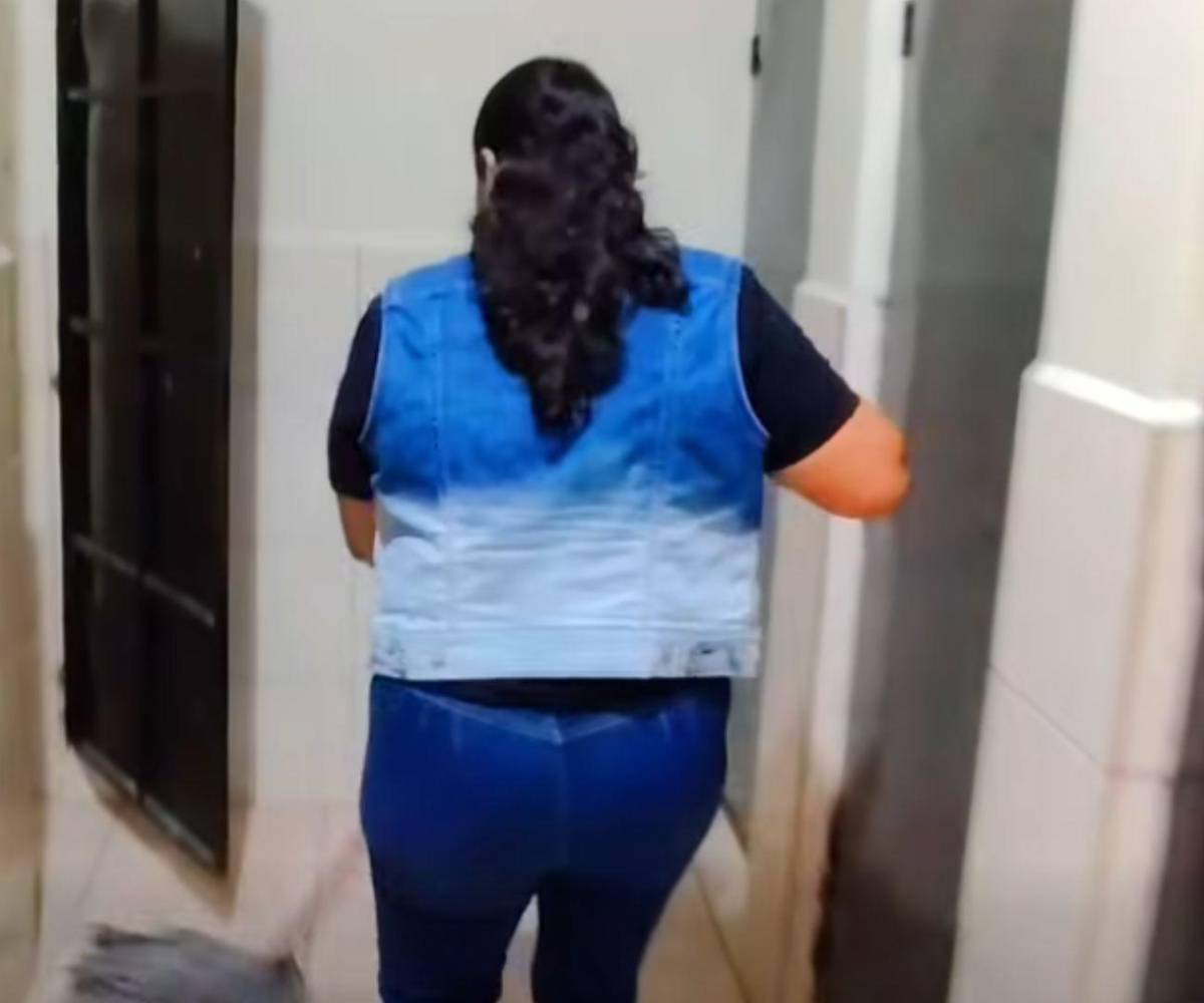 Trapeando los baños del centro educativo en Copán, donde labora por más de ocho horas diarias.