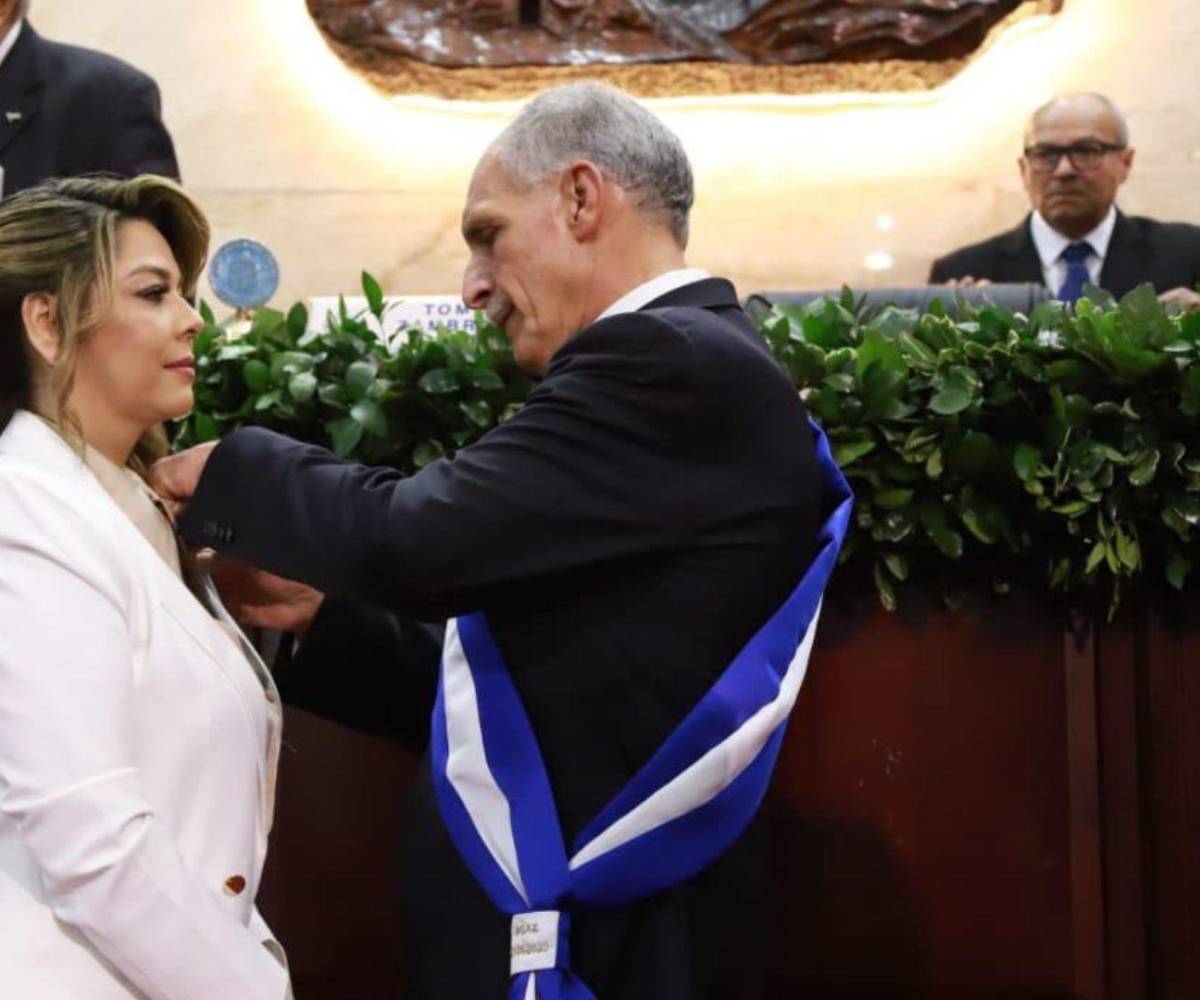 María Antonieta Mejía recibiendo del nuevo gobernante el pin oficial, mientras era juramentada en el Poder Legislativo.
