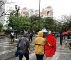 Hondureños se cubren de la lluvia en San Pedro Sula.