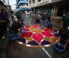 Hombres trabajan con dedicación en la confección de las tradicionales alfombras de aserrín sobre la avenida Cervantes, preparadas para el Santo Entierro de este Viernes Santo.