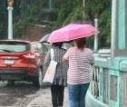 Ciudadanas caminan durante un día lluvioso en Tegucigalpa.