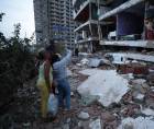 Residentes entre los escombros de uno de los bloques de viviendas dañados por los terremotos, en la localidad de Catia La Mar, en el estado costero de La Guaira (Venezuela) este jueves. EFE/ Ronald Pena R.