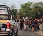 Integrantes de la policía municipal reguardan la seguridad de migrantes que caminan en caravana hacia los Estados Unidos.