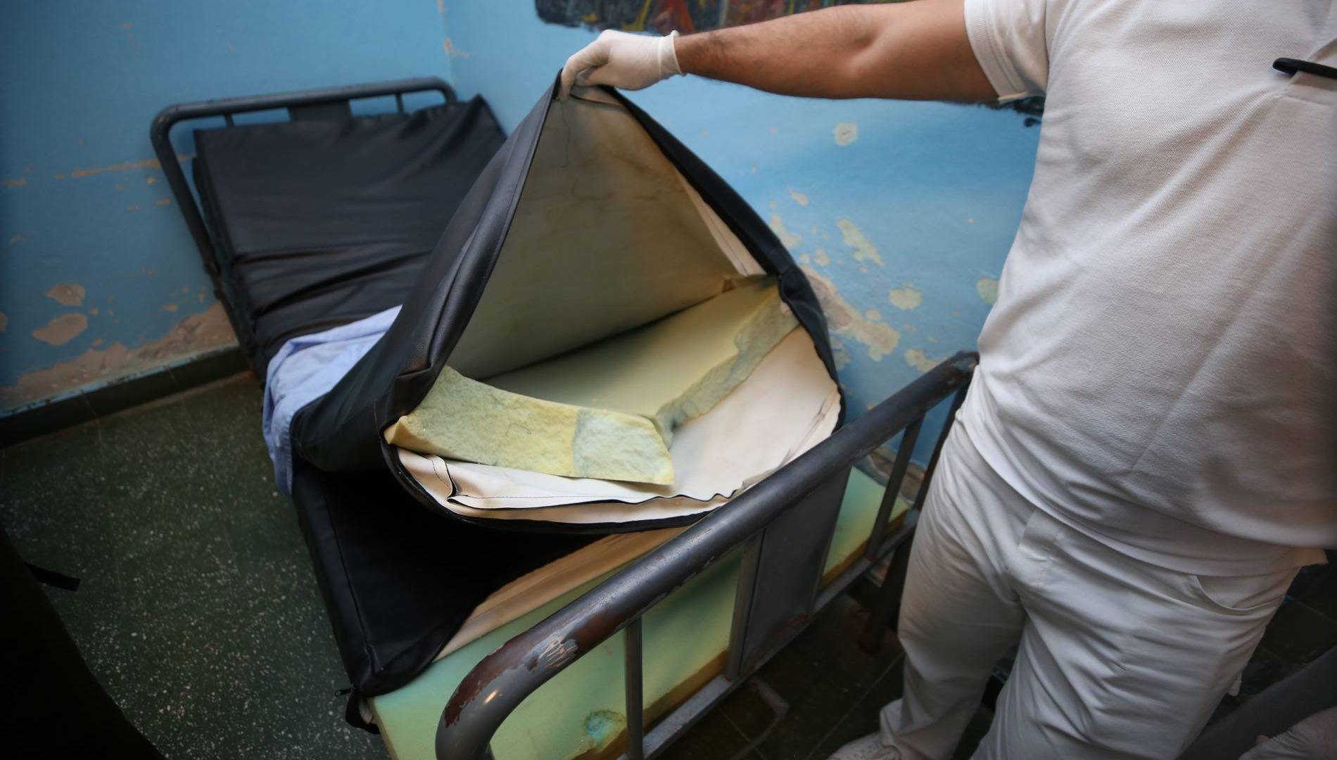 $!Un enfermero mostrando los colchones viejos y rotos de una camilla en la sala de internamiento de hombres.