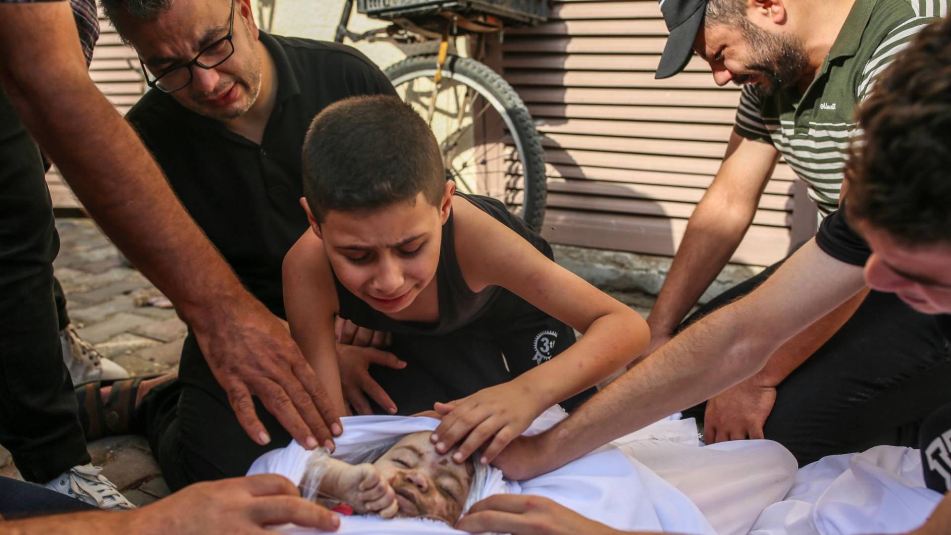 $!Khaled Joudeh, de 9 años, llora ante el cuerpo de su hermanita, Misk, el mes pasado en Deir al Balah, Gaza.