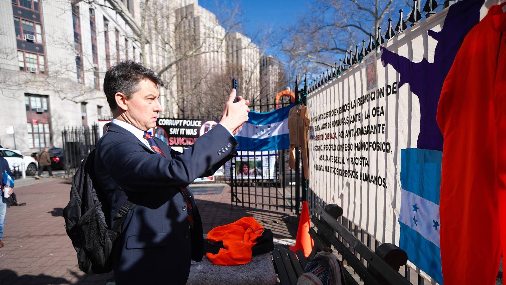 $!El abogado Renato Stabile, de la defensa de JOH, sacó su celular para grabar las pancartas colocadas por los hondureños que protestan frente a la Corte del Distrito Sur de Nueva York.