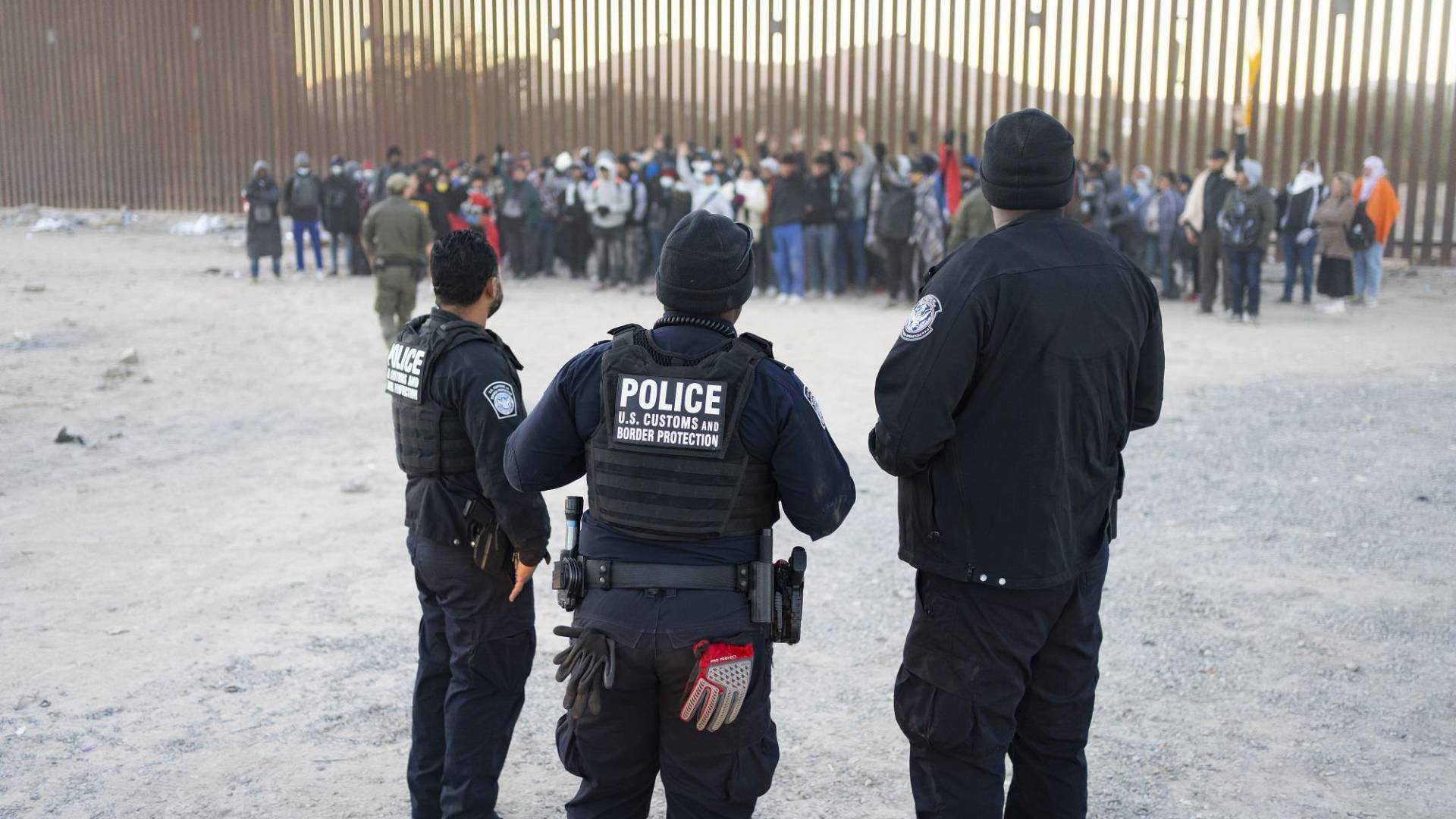 $!Agentes fronterizos vigilan a migrantes que serán llevados a procesamiento cerca de Lukeville, Arizona.