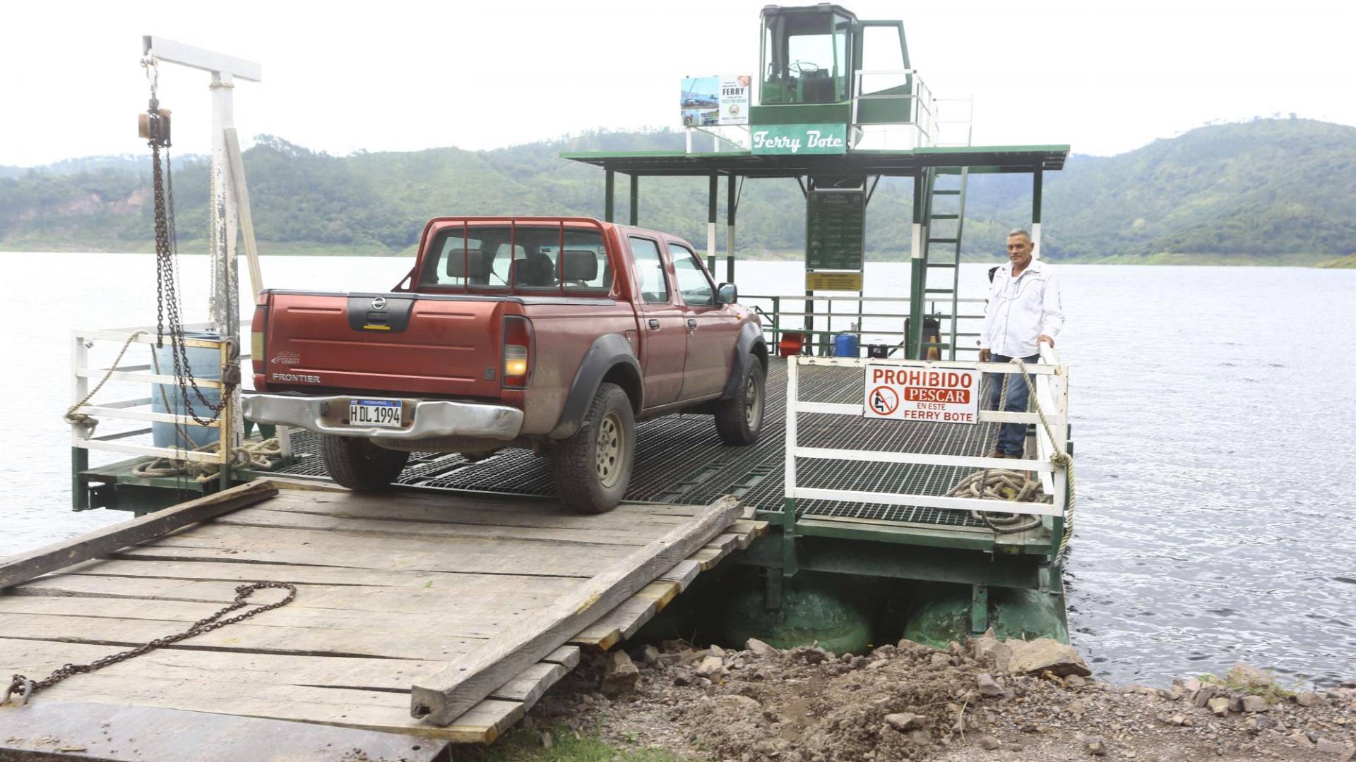 $!Concepción Velásquez conduce el ferri-bote Roberto. En ella traslada a diario, camiones, motos, personas de a pie, un bus y hasta ganado, así como carros particulares, de hasta cuatro por viaje.