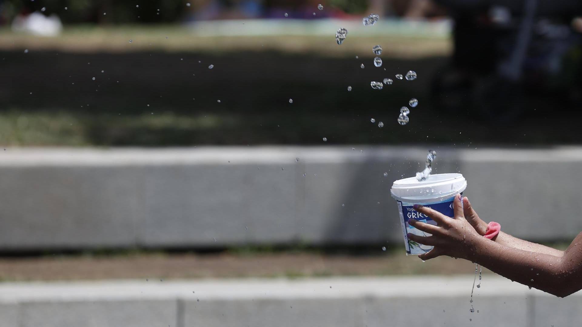 $!Una niña juega en una fuente de chorros en Madrid, este lunes.