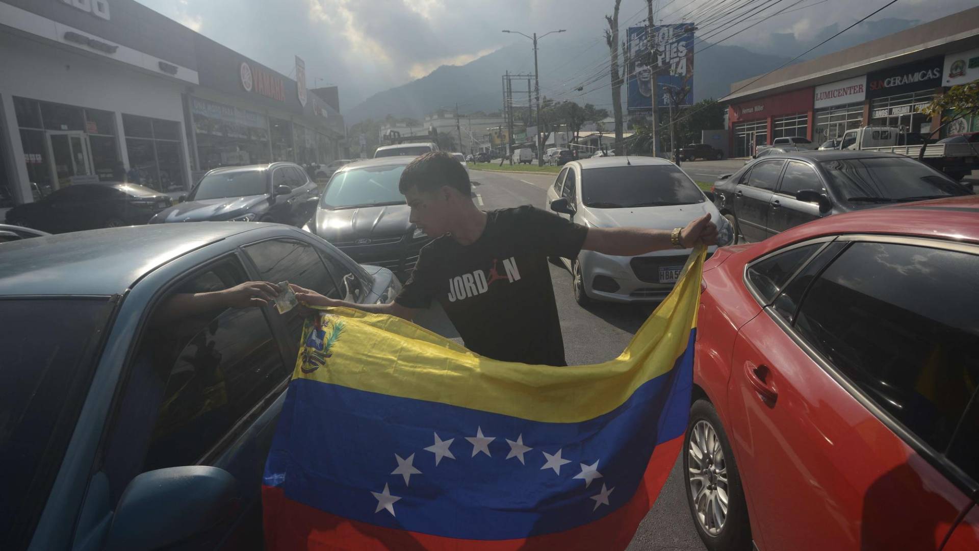 $!Migrante venezolano recibe dinero de un hondureño que transitaba la avenida circunvalación de San Pedro Sula.