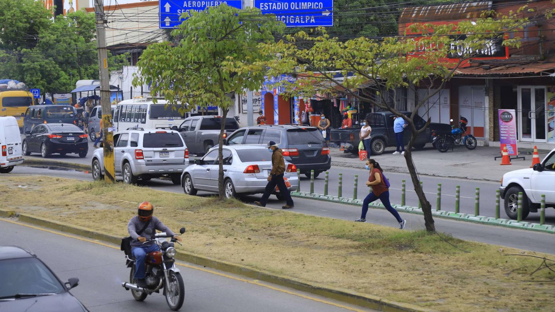 $!Hondureños intentan cruzar el bulevar frente a Mega Mall pese a que tienen disponible un puente peatonal.