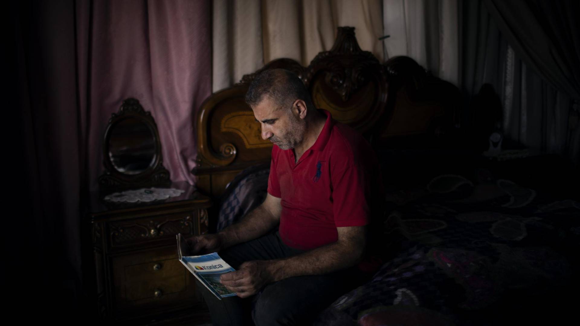 $!Walid al-Hajjar mira fotografías de su esposa, cuyo cáncer lo llevó a amenazar a su banco por su dinero.