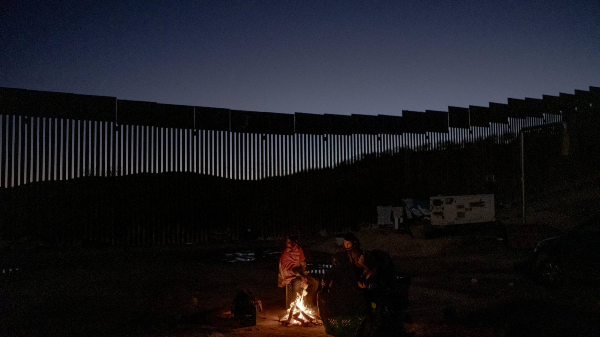$!Migrantes aguardan las patrullas fronterizas en un campamento junto al muro de EU en Sásabe, Arizona.
