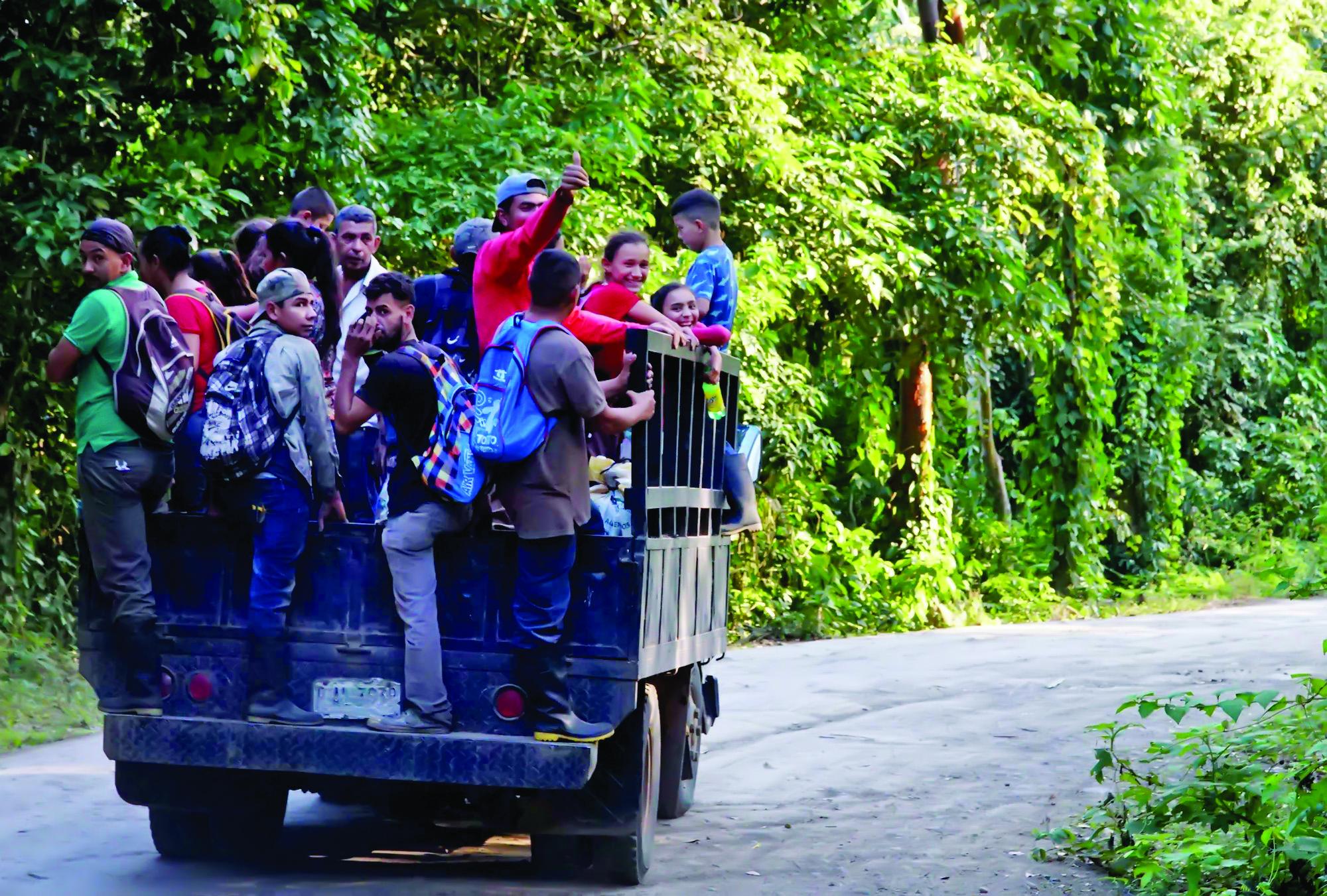 Un grupo de cortadores de café son transportados en un camión tras terminar su jornada diaria.