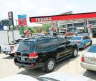 Vehículos hacen fila para cargar combustible en una gasolinera.